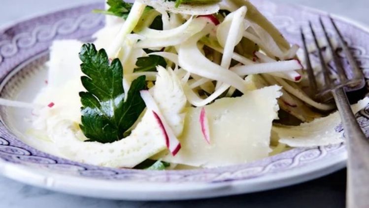 Crisp fennel and artichoke salad with shaved Dry Jack cheese, fresh parsley, and radishes, offering a light and refreshing balance of textures and flavors.
