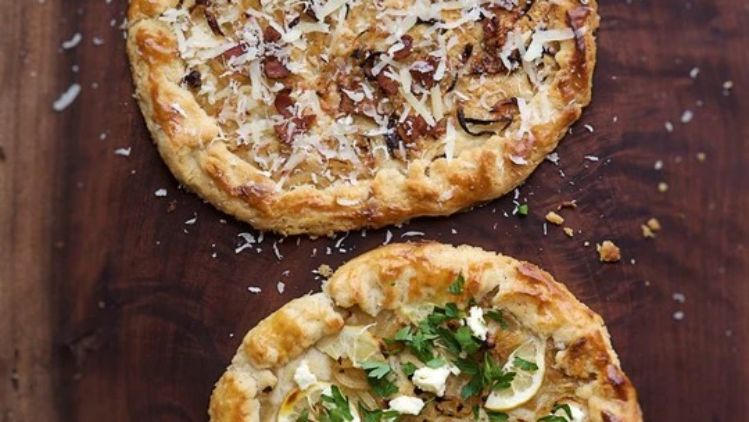 Rustic savory galettes with caramelized onions, bacon, artisan cheese, ricotta, fresh herbs, and lemon, baked in a flaky butter pastry crust.