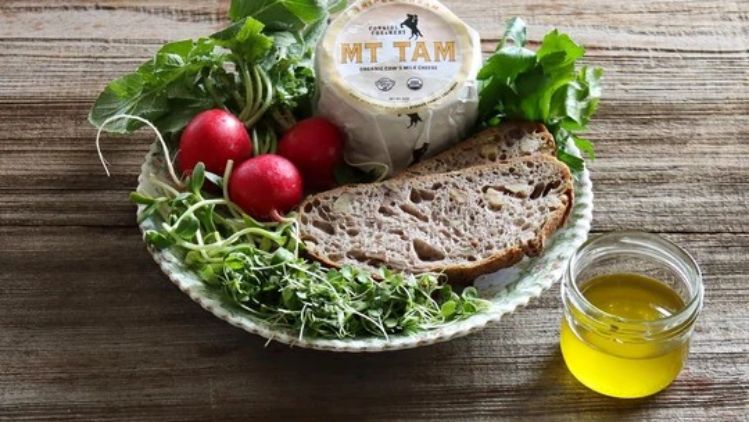 Fresh radish toast ingredients featuring Mt Tam triple cream cheese, crusty artisan bread, crisp radishes, microgreens, and olive oil.