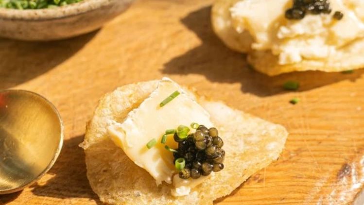 Mt Tam triple cream cheese crostini topped with premium caviar and fresh chives, creating an elegant appetizer with rich, buttery flavors and luxurious texture.