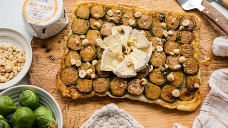 Brussels sprout tart with Mt Tam triple cream cheese and toasted hazelnuts, baked on flaky puff pastry for a rich and elegant seasonal dish.