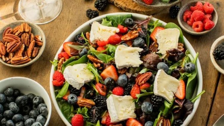 Field greens berry salad with Mt Tam triple cream cheese, fresh strawberries, blueberries, blackberries, and toasted pecans, offering a perfect balance of creamy, sweet, and crunchy flavors.