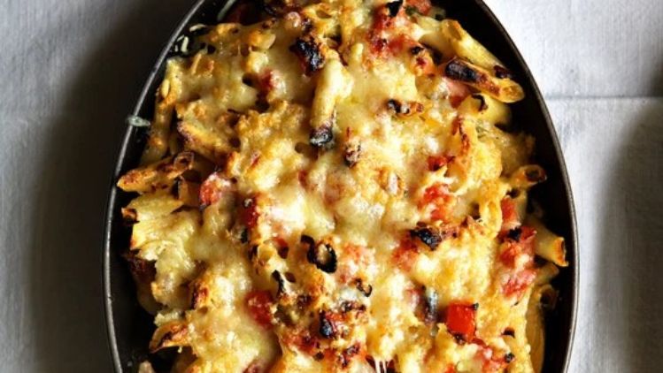 Baked penne pasta casserole with melted artisan cheese, green garlic, and roasted vegetables, finished with a golden, bubbling crust.