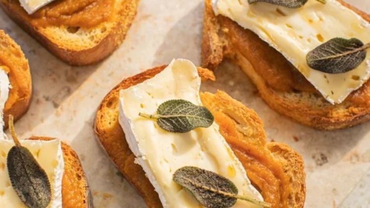 Pumpkin butter crostini topped with creamy Mt Tam triple cream cheese and crispy sage leaves, creating a perfect balance of sweet, savory, and rich flavors.