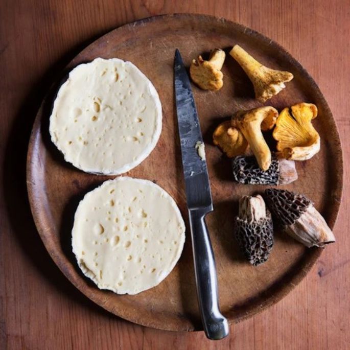 Mt Tam or Camembert cheese sliced horizontally and prepared with fresh wild mushrooms for an elegant layered gourmet recipe.