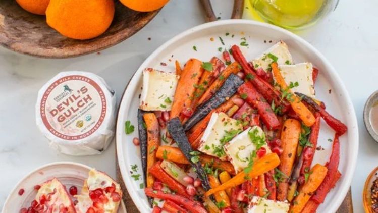 Hot honey roasted carrots with Devil’s Gulch cheese, finished with pomegranate seeds and fresh herbs for a vibrant sweet, spicy, and savory side dish.